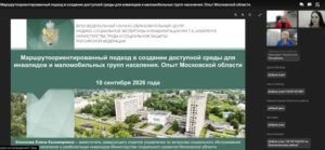 На изображении — слайд презентации. В верхней части — эмблема и полное наименование ФГБУ «Федеральный научно‑образовательный центр медико‑социальной экспертизы и реабилитации им. Г. А. Альбрехта Министерства труда и социальной защиты Российской Федерации». Ниже на тёмно‑зелёном фоне крупным белым шрифтом указано название доклада: «Маршрутоориентированный подход в создании доступной среды для инвалидов и маломобильных групп населения. Опыт Московской области», под ним — дата: «10 сентября 2026 года». В нижней части слайда — аэрофотоснимок комплекса зданий среди зелёных насаждений: видны многоэтажные корпуса, дорожки, небольшие постройки и водоём. Внизу слайда приведена информация о докладчике. Справа — фрагмент интерфейса видеоконференции: в небольших окошках видны лица трёх участников.